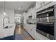 Well-equipped kitchen with stainless steel appliances, white cabinetry, and a view into the dining area at 128 Highland Grove Way, Fuquay Varina, NC 27526