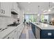 Modern kitchen with white cabinets, an island with bar seating, and stainless steel appliances, perfect for cooking at 128 Highland Grove Way, Fuquay Varina, NC 27526