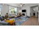 Open living room with fireplace, large windows with outdoor views, and wood floors throughout at 128 Highland Grove Way, Fuquay Varina, NC 27526