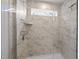 Modern shower featuring marble-patterned tiles, glass enclosure, and sleek fixtures at 128 Highland Grove Way, Fuquay Varina, NC 27526