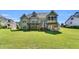 Back exterior showcasing deck, covered patio, stairs, screened porch and manicured lawn at 128 Paraggi Ct, Clayton, NC 27527