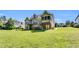 Back exterior showcasing deck, covered patio, stairs, screened porch and lovely lawn at 128 Paraggi Ct, Clayton, NC 27527