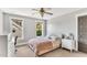 Bright bedroom with two windows, a comfortable bed, a ceiling fan, and neutral colored walls and carpets at 128 Paraggi Ct, Clayton, NC 27527