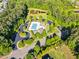 Aerial view of a community pool with parking, playground and mature landscaping at 128 Paraggi Ct, Clayton, NC 27527