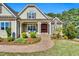 Inviting covered front porch with seating area, wood door with wreath, and stone accents at 128 Paraggi Ct, Clayton, NC 27527
