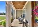 Charming covered front porch with rocking chairs, flagstone flooring, and tongue and groove ceiling at 128 Paraggi Ct, Clayton, NC 27527