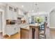 Bright kitchen with stainless appliances, white cabinets, and a long marble breakfast bar at 128 Paraggi Ct, Clayton, NC 27527