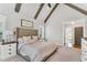 Light filled main bedroom with a vaulted ceiling, exposed beams, a large window, and a tufted headboard at 128 Paraggi Ct, Clayton, NC 27527