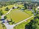 Aerial view of a tranquil pond surrounded by lush green pastures and farmhouses at 128 Paraggi Ct, Clayton, NC 27527