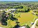 Aerial view of a large pond with surrounding trees and buildings, including a large equestrian complex at 128 Paraggi Ct, Clayton, NC 27527