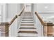 Elegant staircase with wooden handrail and white risers leading to the upper level at 128 Paraggi Ct, Clayton, NC 27527