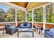 Bright sunroom featuring wood paneled walls, wooded views, wicker furniture and string lights for cozy evenings at 128 Paraggi Ct, Clayton, NC 27527