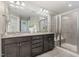 Elegant bathroom with double vanity, granite countertop, decorative mirrors, and a glass-enclosed shower at 1314 Catch Fly Ln, Durham, NC 27713