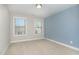 A simple bedroom featuring neutral walls, two windows, and plush carpeting at 1314 Catch Fly Ln, Durham, NC 27713