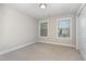 Bright bedroom featuring neutral carpet, two windows, a ceiling light and closet at 1314 Catch Fly Ln, Durham, NC 27713