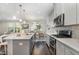 Modern kitchen featuring a large island, stainless steel appliances, and a view of the dining and living spaces at 1314 Catch Fly Ln, Durham, NC 27713