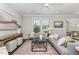 Bright living room with stylish decor, large windows, and hardwood floors throughout at 1314 Catch Fly Ln, Durham, NC 27713