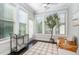 Bright sunroom with lots of natural light, dark wood floors, modern furniture, and a stylish beverage cart at 1314 Catch Fly Ln, Durham, NC 27713