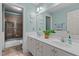Well-lit bathroom featuring double sinks, a large mirror, and a shower-tub combination at 1401 Marshall Farm St, Wake Forest, NC 27587