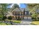 Two-story brick home featuring a welcoming front porch and a two-car garage in a landscaped setting at 1401 Marshall Farm St, Wake Forest, NC 27587