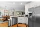 Well-lit kitchen with stainless steel appliances, including a refrigerator and dishwasher, and a view to dining area at 1401 Marshall Farm St, Wake Forest, NC 27587