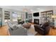Bright living room featuring a fireplace, built-in shelving, large windows, and comfortable sofas at 1401 Marshall Farm St, Wake Forest, NC 27587