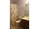 Functional bathroom with a floral shower curtain, toilet, and vanity with a wooden cabinet at 1410 Osborne Dr, Burlington, NC 27215
