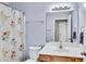 Clean bathroom with a single vanity, floral shower curtain, and a large mirror at 1410 Osborne Dr, Burlington, NC 27215