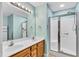 Bathroom featuring a double vanity, a large mirror, and a walk-in shower with glass doors at 1410 Osborne Dr, Burlington, NC 27215