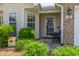 Inviting front porch with door wreath, accent furniture, a Welcome sign, and manicured landscaping at 1410 Osborne Dr, Burlington, NC 27215