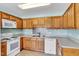 Traditional kitchen with light wood cabinetry, white appliances, and a tiled backsplash at 1410 Osborne Dr, Burlington, NC 27215
