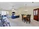 Open living space with fireplace, ceiling fan, neutral carpet, and access to a sunroom at 1410 Osborne Dr, Burlington, NC 27215