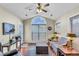 Cozy sunroom with large window, ceiling fan, hardwood floor, and comfortable furnishings at 1410 Osborne Dr, Burlington, NC 27215