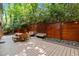 Charming outdoor living space with a dining table, benches, string lights, and privacy fence at 1509 Cumberland Rd, Chapel Hill, NC 27514
