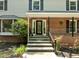 A charming two-story home with a brick facade, covered porch, and black-framed door at 1509 Cumberland Rd, Chapel Hill, NC 27514