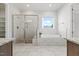 Bathroom showcasing a glass shower, a soaking tub by a window, and tiled flooring at 1513 Armscroft Lane, Apex, NC 27502