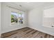 A sunlit bedroom with wood-look floors, neutral walls, and large windows at 1513 Armscroft Lane, Apex, NC 27502