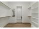 Spacious walk-in closet with custom shelving and hardwood flooring at 1513 Armscroft Lane, Apex, NC 27502
