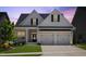 Charming home featuring a two-car garage, landscaped yard, and stylish black and white accents at 1513 Armscroft Lane, Apex, NC 27502
