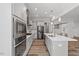 Bright modern kitchen with stainless steel appliances and island sink at 1513 Armscroft Lane, Apex, NC 27502