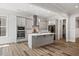 Modern kitchen featuring an island, stainless steel appliances, and gray cabinetry at 1513 Armscroft Lane, Apex, NC 27502