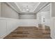 Living room with a tray ceiling, wood-look floors, and modern trim at 1513 Armscroft Lane, Apex, NC 27502