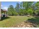 Expansive backyard with lush lawn, mature trees, and charming covered patio area at 1605 Sassafras St, Durham, NC 27712