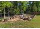 Backyard space with a stone fire pit surrounded by comfortable seating and stump stools at 1605 Sassafras St, Durham, NC 27712
