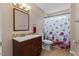Bathroom featuring dark wood vanity, updated mirror, and shower with modern floral shower curtain at 1605 Sassafras St, Durham, NC 27712