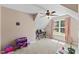 Cozy bedroom featuring sloped ceilings, ceiling fan, and natural light at 1605 Sassafras St, Durham, NC 27712