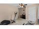 Bedroom with a ceiling fan and carpet, along with exercise equipment, television, and door at 1605 Sassafras St, Durham, NC 27712