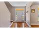 Open entryway with hardwood floors, a white front door with sidelights and a staircase at 1605 Sassafras St, Durham, NC 27712