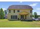 Two-story home features yellow siding, a well-manicured lawn, and rear patio at 1605 Sassafras St, Durham, NC 27712