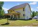 Two-story home features yellow siding, a well-manicured lawn and covered rear patio at 1605 Sassafras St, Durham, NC 27712
